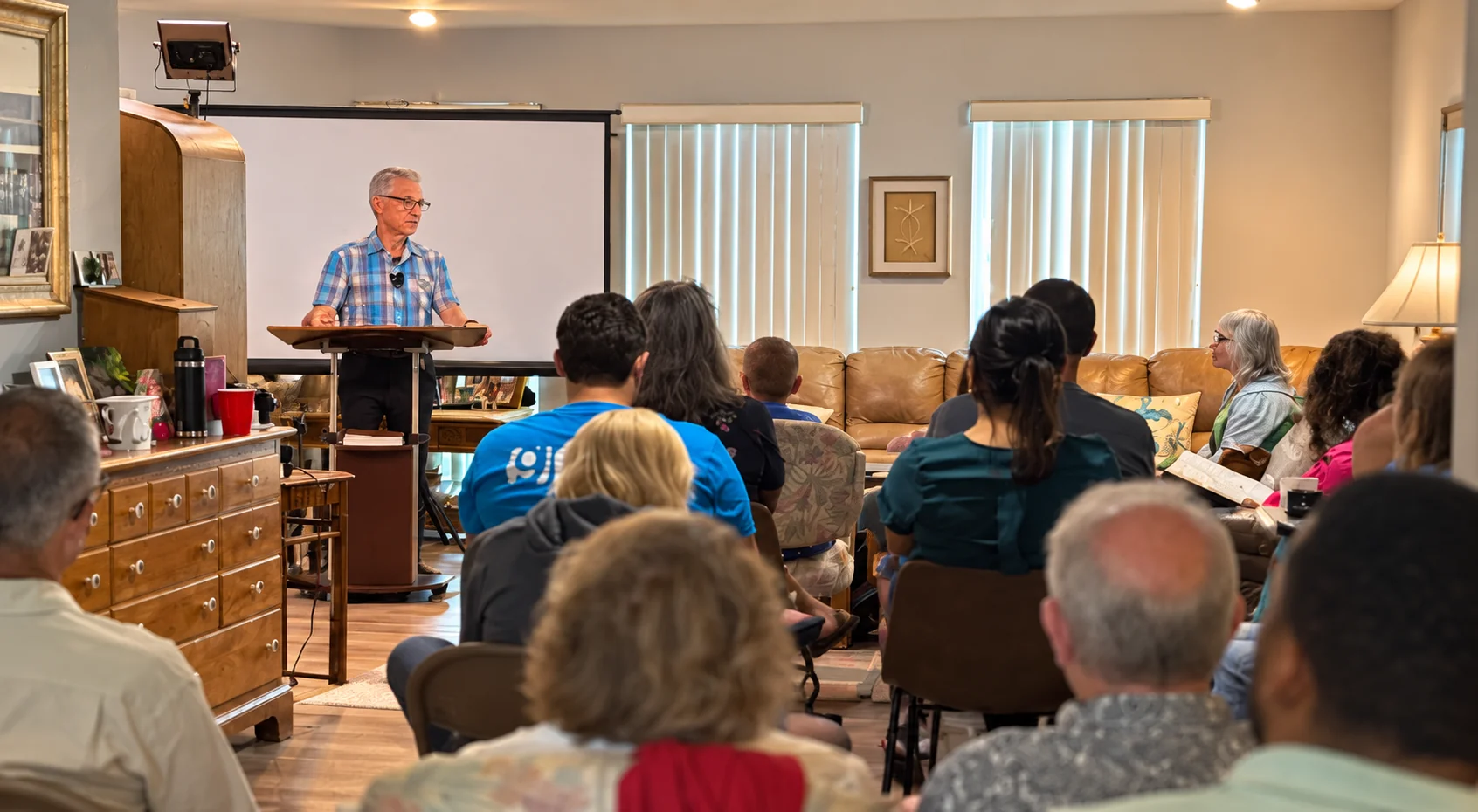 Pastor Frank speaking to the Grace & Peace Church congregation gathered in a home